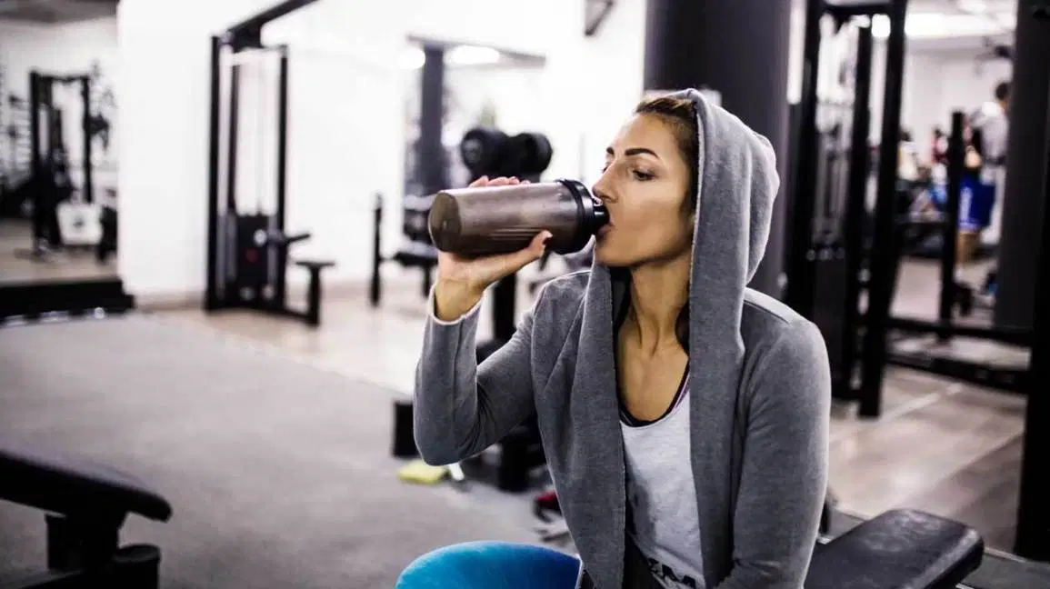 Woman in Gym Drinking a Protein Shake